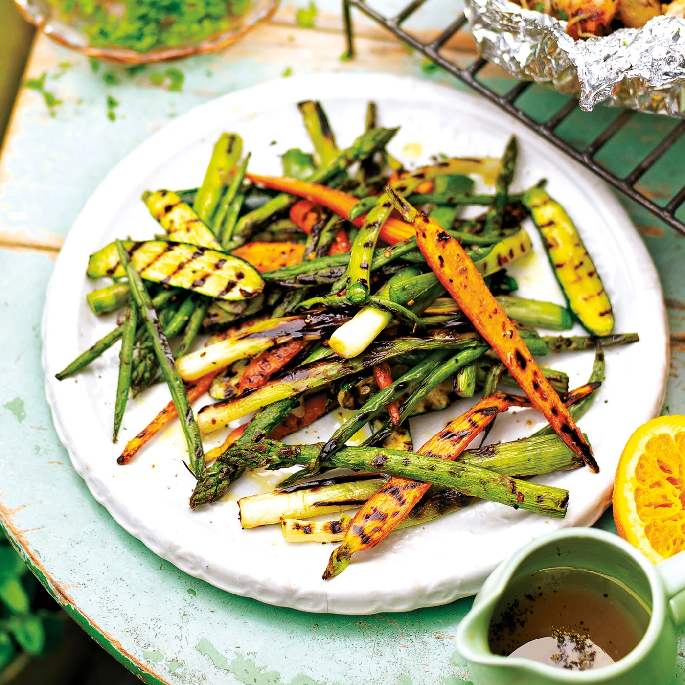 Det bästa du kan göra med grillade grönsaker är att vända de i en smakrik dressing med bland annat apelsin och spiskummin.